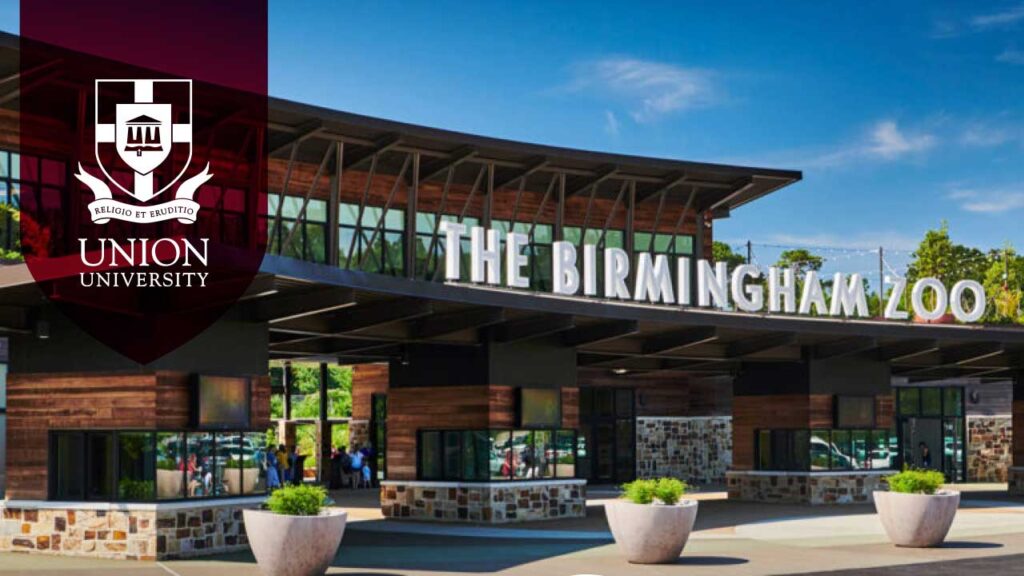 The entrance to the Birmingham Zoo with large signage above modern architecture and a Union University logo and crest overlaid in the left corner of the image, capturing a vibrant gathering spot for alumni to enjoy brunch in Birmingham.