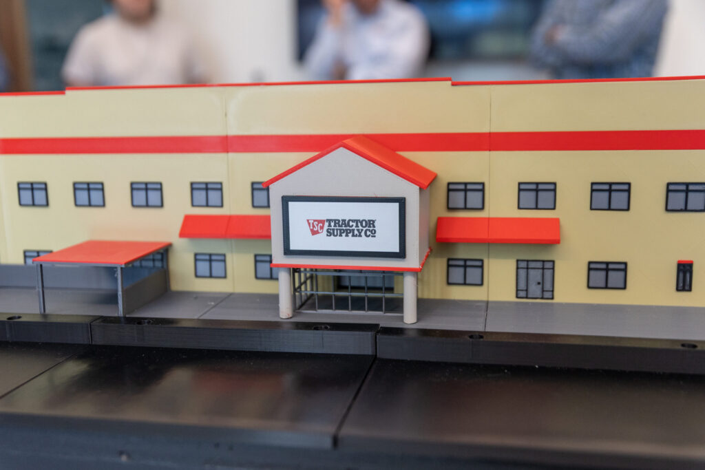 A scale model of a Tractor Supply Co. store building featuring a prominent entrance sign and rows of windows.