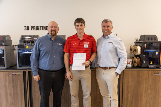 Georg Pingen, of the Engineering Department, holds a donation from Tractor Supply
